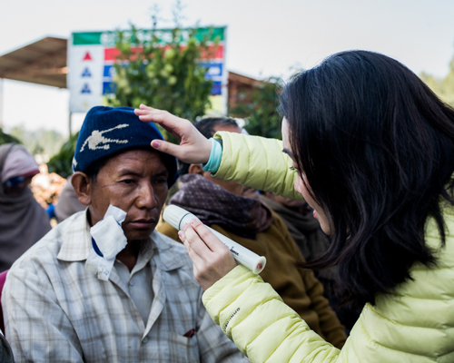 陈婉慧医生到海外社区做义工，帮助一位尼泊尔白内障术后患者进行眼部检查